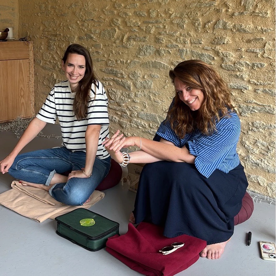 Charline et Léna, assises sur des coussins de méditation, tout sourire